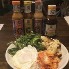 Kimchi, fried egg, cauliflower, and lettuce with four types of Soy Vay® Sauces